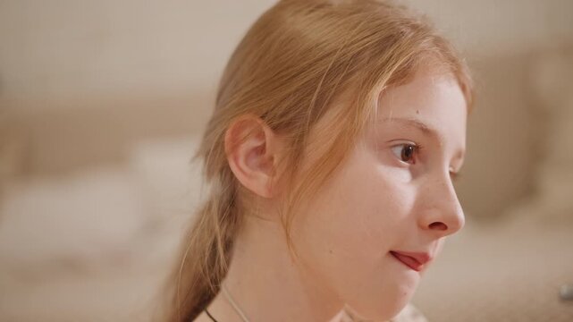 Closeup bedroom portrait girl journaling, sketching and daydreaming in warm natural light softfocus background with freckles and braided hair marker and notebook in hand poses suggest student, artist,