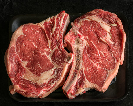 Fresh rib eyed steak with a a black background.
