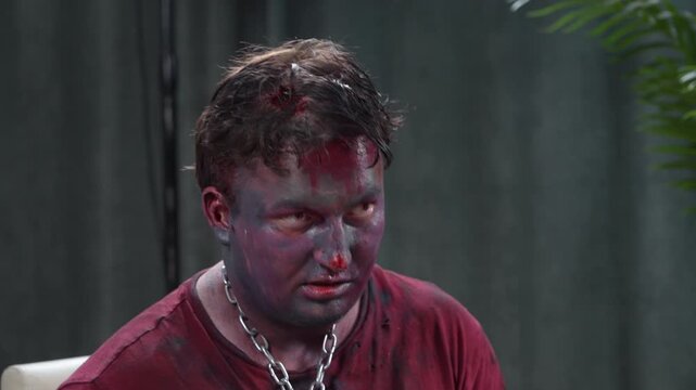 A man transformed into a menacing zombie with professional sfx makeup, chained and bloodied, raw horror energy for Halloween or thriller production use.