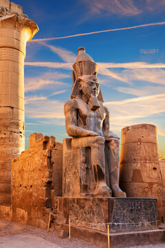 Sunset view of Ramesses II seated by the Luxor Temple entrance, Egypt