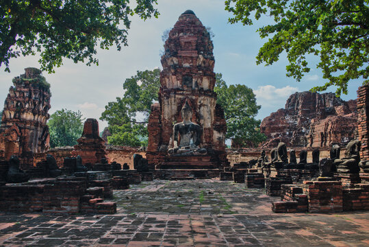 Wide courtyard of an ancient brick temple complex with central prang and surrounding ruins at Ayutthaya Historical Park, Thailand.