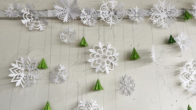 Hanging white snowflakes and green trees for a winter decoration activity