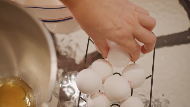 Overhead white eggs near mixing bowl as family matriarch cracks eggs for pumpkin pie, vintage ceramic jug and stainless bowl, amber yolks pooling, slow deliberate motions, sentimental warm kitchen,
