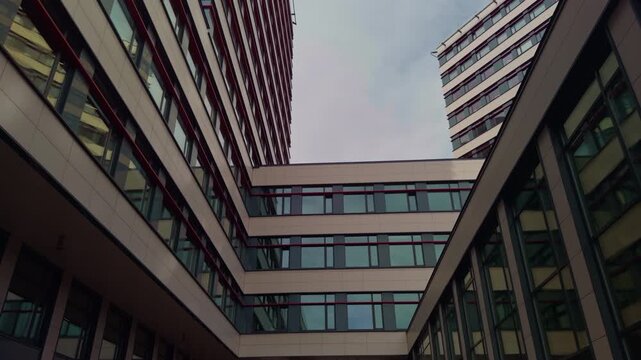 Hospital: Reflective surfaces in corporate glass architecture. Commercial area with uniform windows and peaceful ambiance