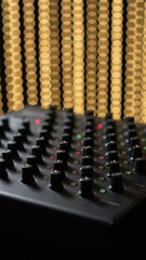 Fototapeta premium Audio mixer control knobs with golden bokeh background.