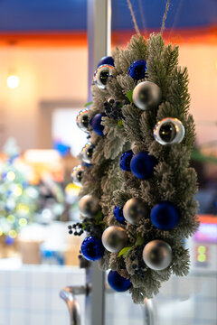 A round evergreen tree decorated with blue and silver Christmas ornaments, creating a festive, elegant, and winter holiday atmosphere.