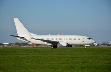 Obraz premium Boeing B737-700 all white livery blank on a sunny spring day at an international airport operating for an airline