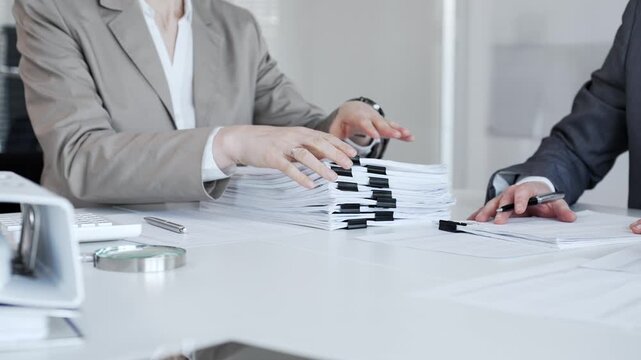 Business professionals analyzing documents and paperwork, calculating finances in an office environment. Audit and taxes in business