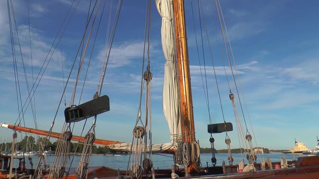 Helsinki, Finland. Sailing schooner at the pier, rigging the schooner. Masts against the blue sky. Warm summer evening.
