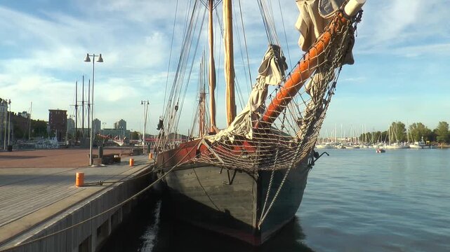 Helsinki, Finland. Sailing schooner at the pier, schooner bowsprit.
  Warm summer evening.