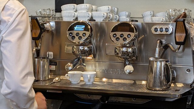 Professional espresso machine in Italian cafe close up, barista workspace with coffee cups, stainless steel coffee equipment, cafe interior, coffee culture concept