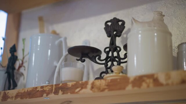 White enamel jars on wooden shelf, iron trivet and chipped paint, warm morning light, home cook arranging utensils, nostalgic rustic kitchen still life, ceramic and metal textures
