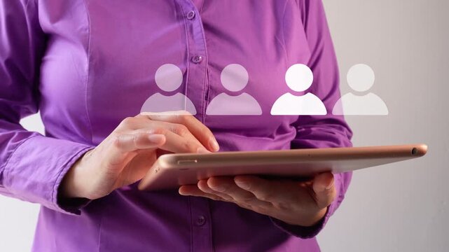 Close-up of a businesswoman interacting with her tablet, showing a row of avatars, one of which stands out. This indicates the correct personnel selection.