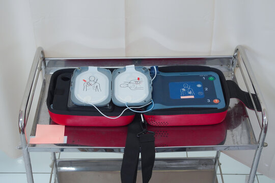 Automated External Defibrillator (AED) with pads on a medical cart