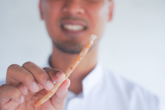 Man holding miswak for traditional oral hygiene