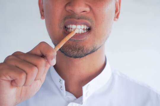 Man holding miswak for traditional oral hygiene