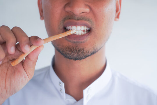Man holding miswak for traditional oral hygiene