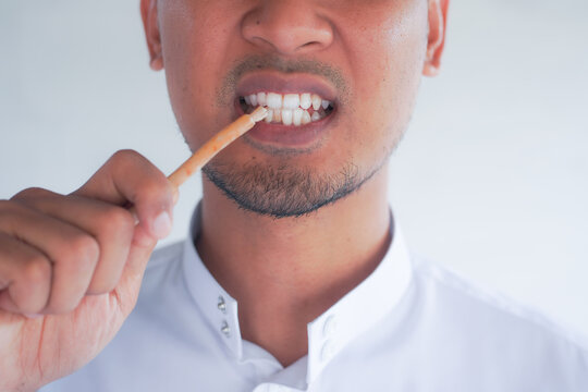 Man holding miswak for traditional oral hygiene