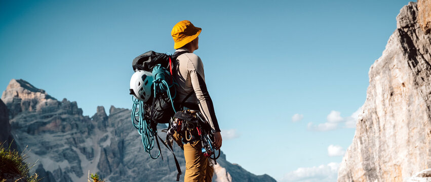 A young athlete man prepares for climbing, mountaineering outdoors.
