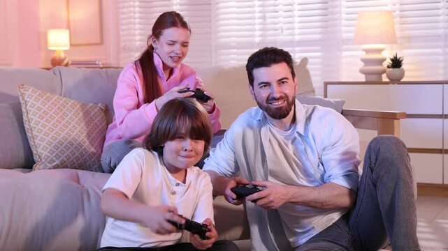 Emotional family with controllers playing video game together at home