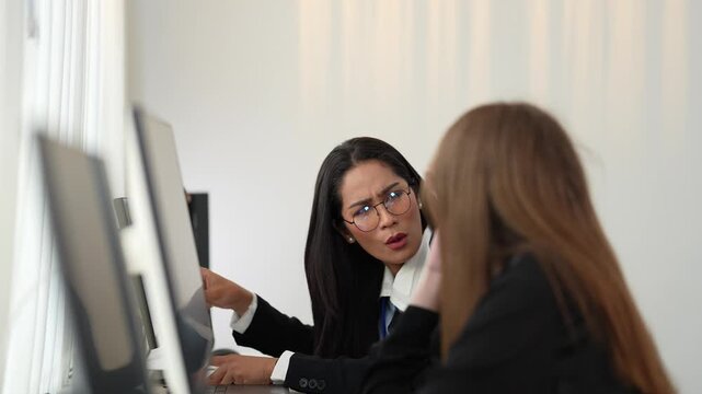 Poised cross functional specialists featuring senior female executive and young female analyst overseeing complex electronic systems and software code at a high tech operations center at night.