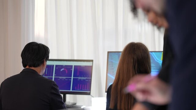 International multicultural experts featuring senior male executive and young female analyst managing digital safeguard protocols and network security in a sophisticated dark workspace hub.