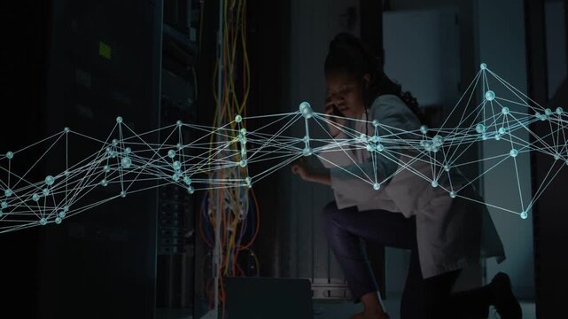 Female network engineer noticing animated alert and troubleshooting cables in server aisle, calling