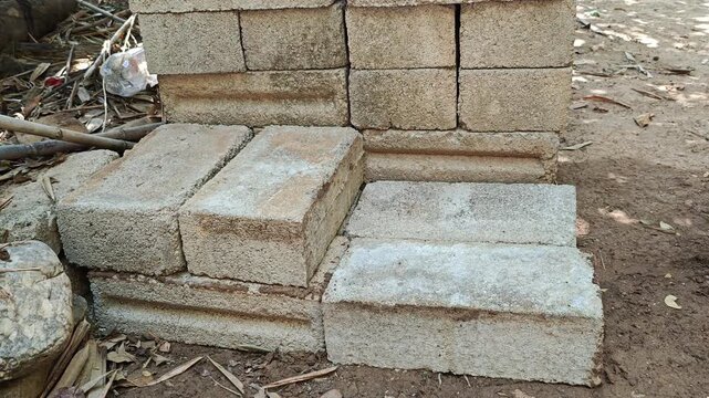 Construction worker laying concrete blocks in a row for a wall foundation