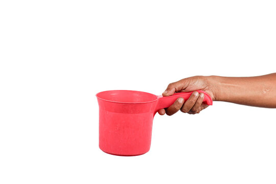 Hand holding red plastic water dipper or bailer isolated on white background.