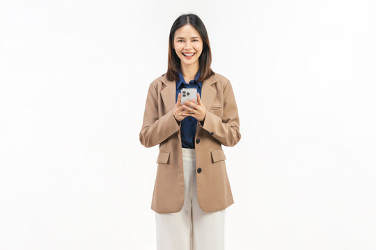 Smiling young Asian businesswoman using smartphone and pointing at mobile screen on white studio background.
