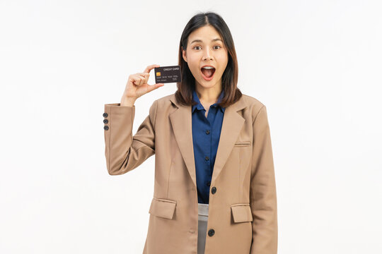 Happy young Asian businesswoman holding credit cards and a confident smile isolated on white studio background.