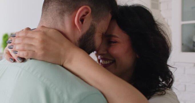 Couple smile with love and care, intimacy and romantic relationship on dating at home. Happy woman and man touch foreheads and laugh in kitchen, spouses share trust and playful mood in moment