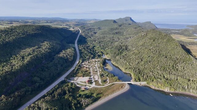 Aerial view of Bic National Park coastline, forest, campground and calm bay under blue sky. g.