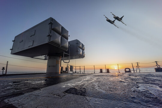 A military planes flies over a warship during a peacekeeping operation in the Black Sea.
