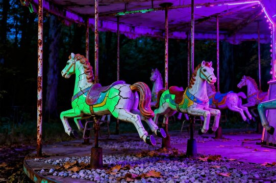 Rusted Abandoned Carousel at Night with Electric Purple and Acid Green Neon Light
