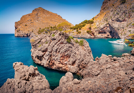 Wonderful summer view of popular tourist attraction - Es Colomer with white yacht in the bay. Amazing morning seascpae of Balearic Sea. Nice landscape of Mallorca Island, Balearic Islands, Spain