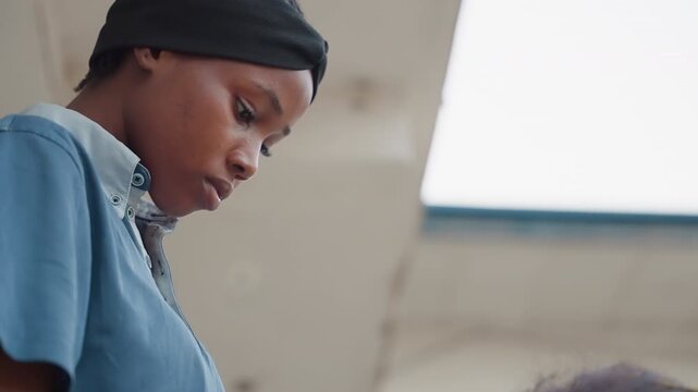 Young woman measuring wood plank, low angle profile shot in workshop, steady posture checking layout, tape and ruler details, overhead skylight, thoughtful expression and focused technique, authentic