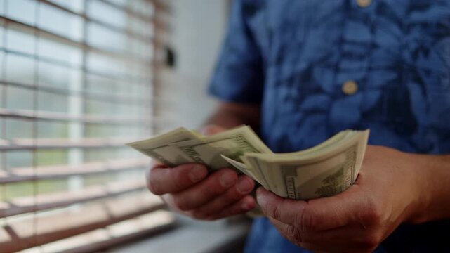 A person carefully counts bills, anticipation filling the air. Sunlight streams through the blinds, creating a warm atmosphere for this special activity