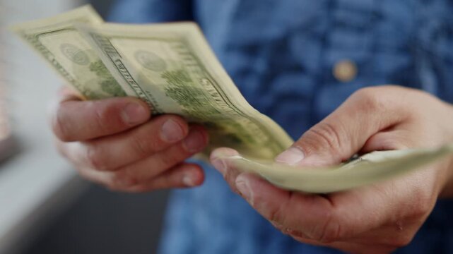 Bright sunlight streams into a cozy room as hands skillfully count and organize fresh bills, creating a moment of calm and focus amidst the hustle