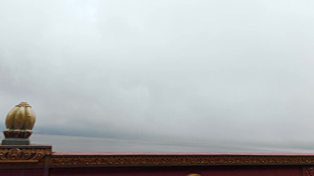 Driving Past Lake Bratan Bali on Cloudy Day with Decorative Bridge Wall