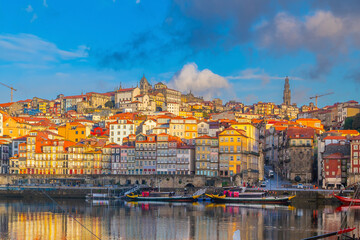 Obraz premium View of Porto's Ribeira district and traditional Rabelo boats on Douro River at sunset