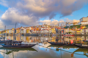 Obraz premium View of Porto's Ribeira district and traditional Rabelo boats on Douro River at sunset