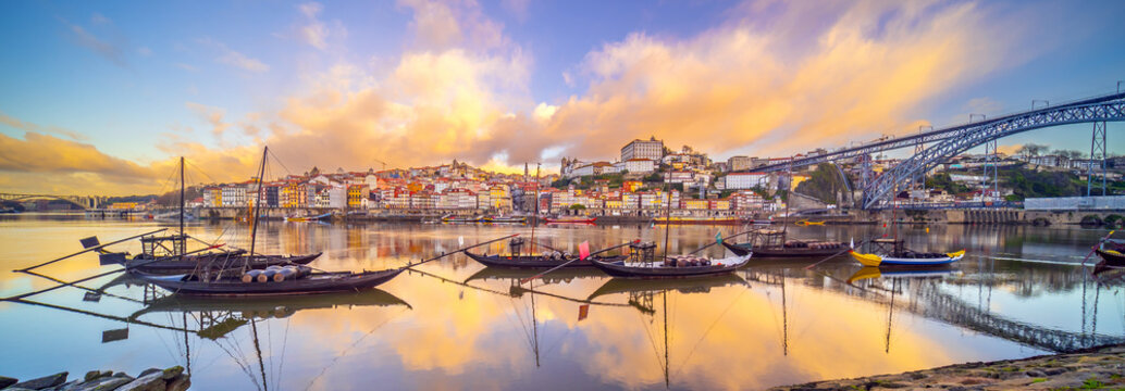View of Porto's Ribeira district and traditional Rabelo boats on Douro River at sunset