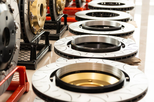 Close up brake disc rotors with drilled and slotted surface performance automotive parts displayed in workshop high quality metal components for vehicle braking system
