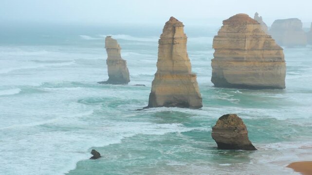 Dramatic slow motion footage of waves crashing against rugged sea stacks along the twelve apostles coastline.