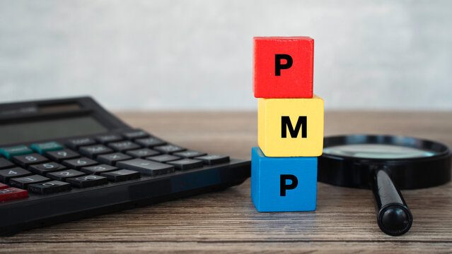 Project Management Professional PMP acronym on colorful toy blocks with calculator and magnifying glass.