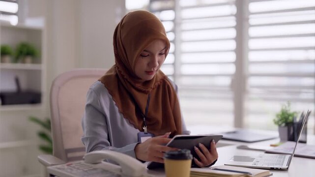 Asian adult woman professional business work modern office setting using digital tablet technology productivity focused tasks