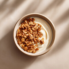 Obraz premium Yogurt with granola in neutral bowl overhead view showcasing creamy texture and crunchy topping in clean eating breakfast modern aesthetic
