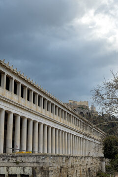 Vertical photo of the Stoa of Attalos , the Museum of the Ancient Agora at Athens-Greece. Sky with clouds at the background, the Acropolis behind the building.