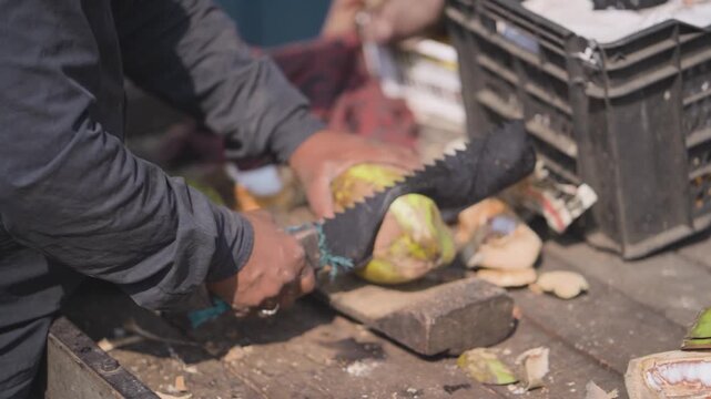 Cutting fresh green coconut, Street vendor preparing coconut, Coconut chopping roadside scene, Fresh coconut water preparation stock video.